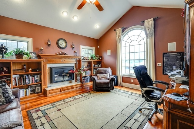 home office with light hardwood / wood-style flooring, vaulted ceiling, and a healthy amount of sunlight