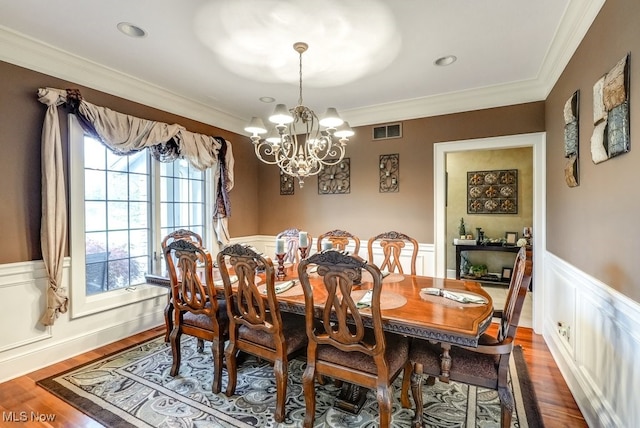 dining room featuring dark hardwood / wood-style floors, ornamental molding, and a chandelier