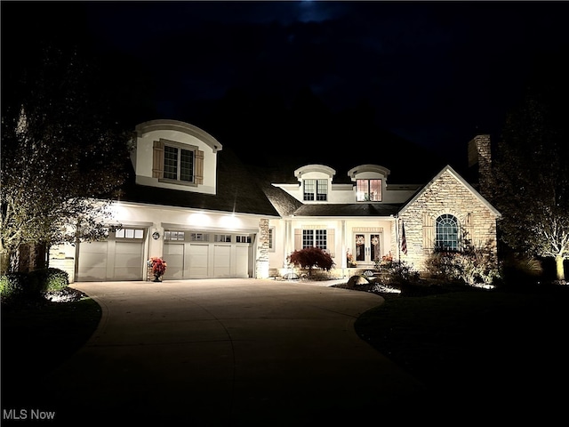 french country inspired facade with a garage and french doors