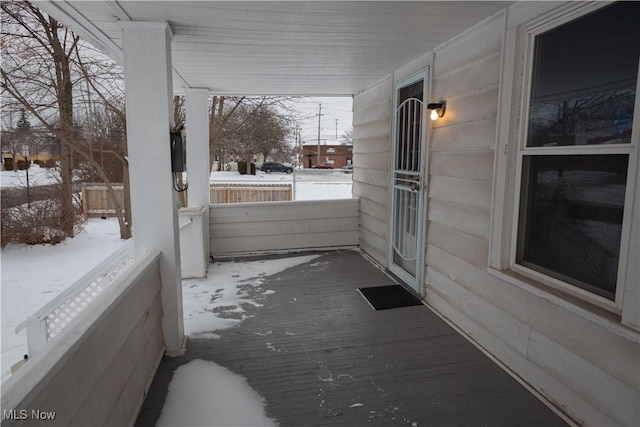 view of snow covered back of property