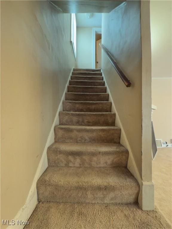 staircase featuring carpet flooring and baseboards