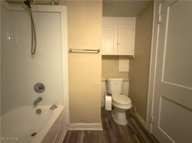 bathroom with  shower combination, a textured ceiling, baseboards, and wood finished floors