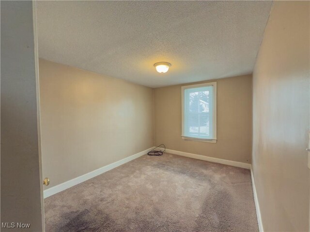 empty room featuring carpet and a textured ceiling