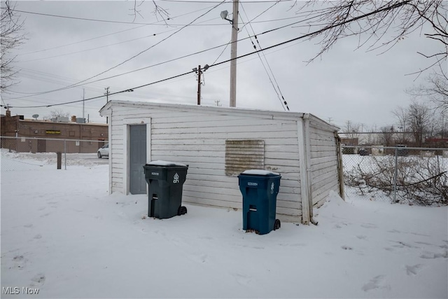 snow covered structure with fence