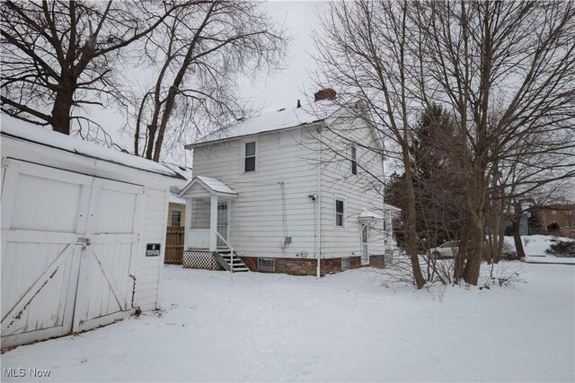 snow covered property with a storage unit