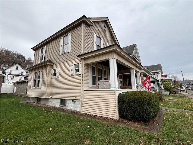 view of side of home with a porch and a lawn