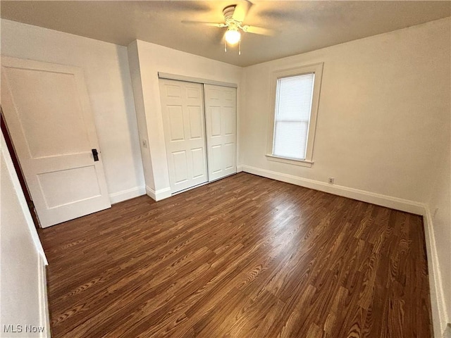 unfurnished bedroom featuring dark wood-type flooring, ceiling fan, and a closet