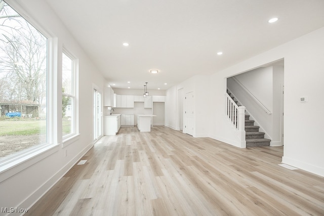 unfurnished living room with light hardwood / wood-style floors and sink