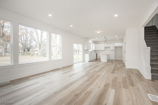 unfurnished living room with light hardwood / wood-style floors and plenty of natural light