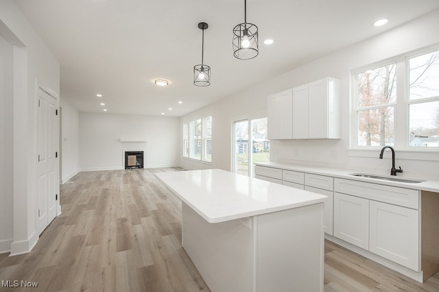 kitchen featuring white cabinets, plenty of natural light, and sink