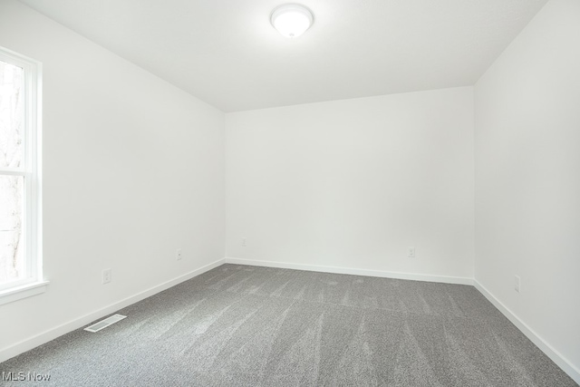 carpeted spare room featuring plenty of natural light