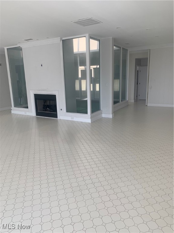 unfurnished living room with ornamental molding