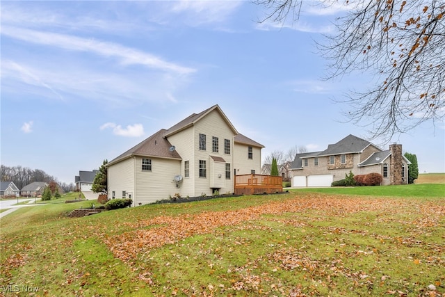 view of side of home with a deck, a garage, and a lawn