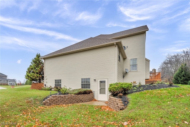 rear view of house with a lawn and a wooden deck