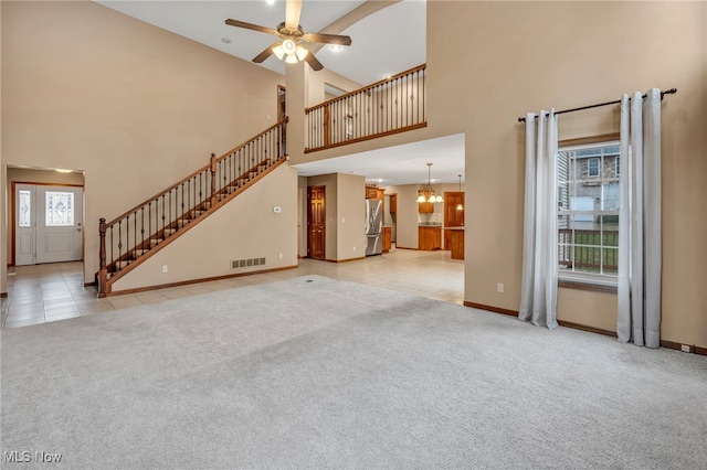 unfurnished living room with stairs, light colored carpet, visible vents, and ceiling fan