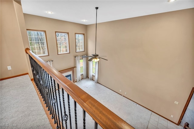 stairs featuring carpet flooring and ceiling fan