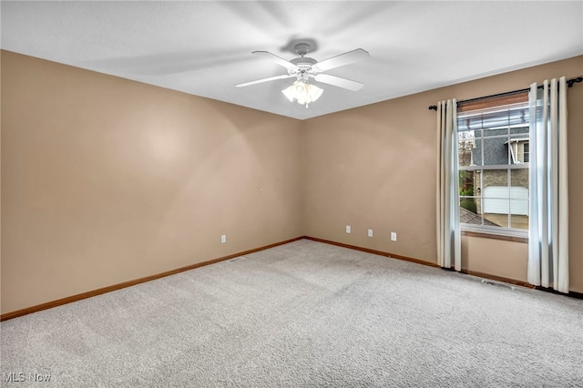 carpeted empty room featuring baseboards and ceiling fan