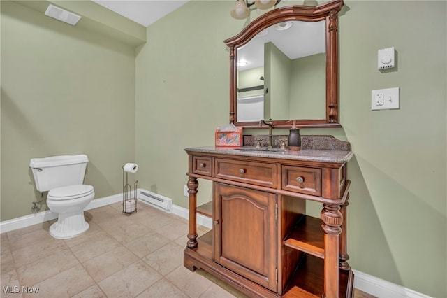 half bathroom featuring a baseboard heating unit, toilet, vanity, and baseboards