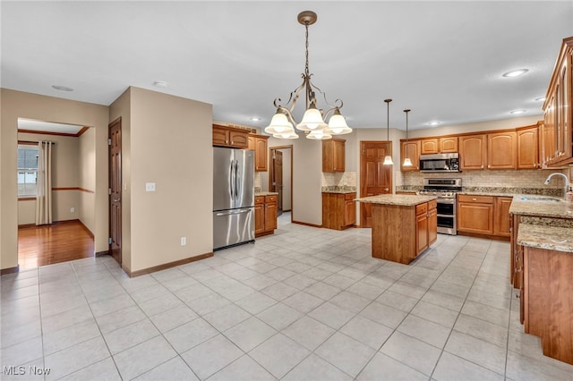 kitchen with brown cabinets, a sink, a center island, stainless steel appliances, and decorative backsplash