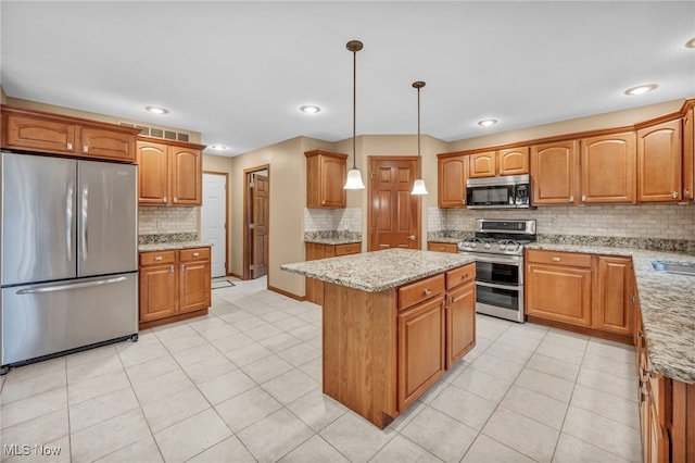 kitchen with decorative light fixtures, a kitchen island, light stone counters, and appliances with stainless steel finishes