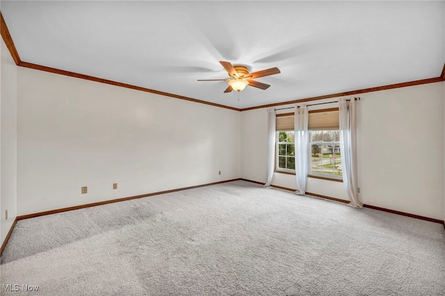 unfurnished room with carpet flooring, baseboards, crown molding, and a ceiling fan
