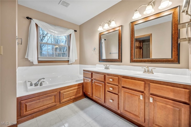 bathroom with tile patterned floors, vanity, and a bathing tub