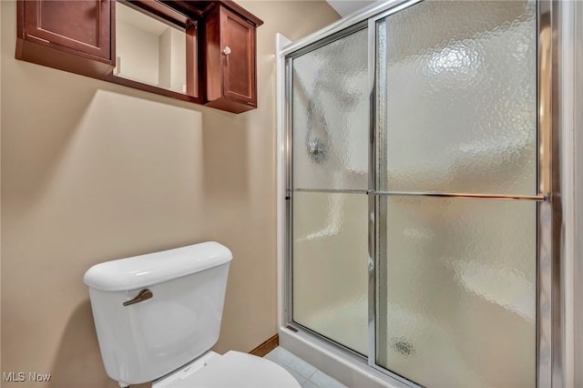 bathroom with tile patterned flooring, toilet, and walk in shower