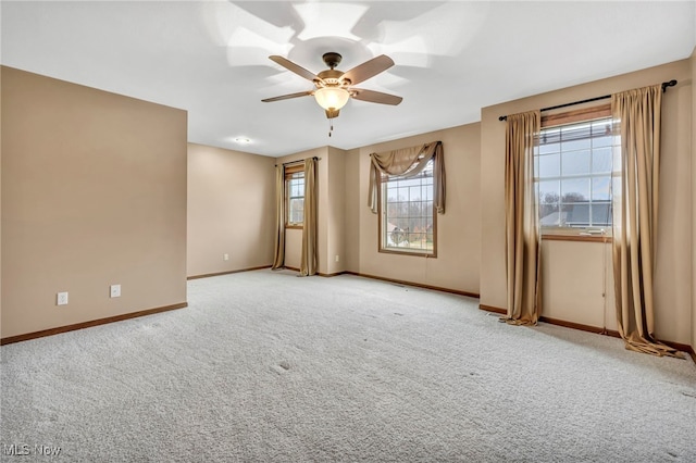 spare room with ceiling fan and light carpet