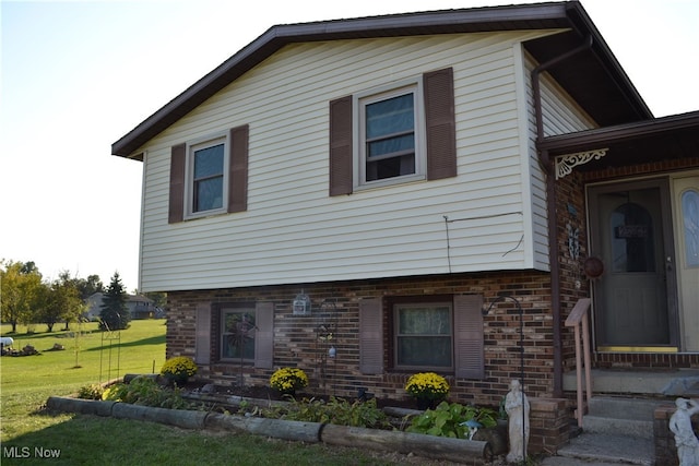 rear view of property featuring a lawn