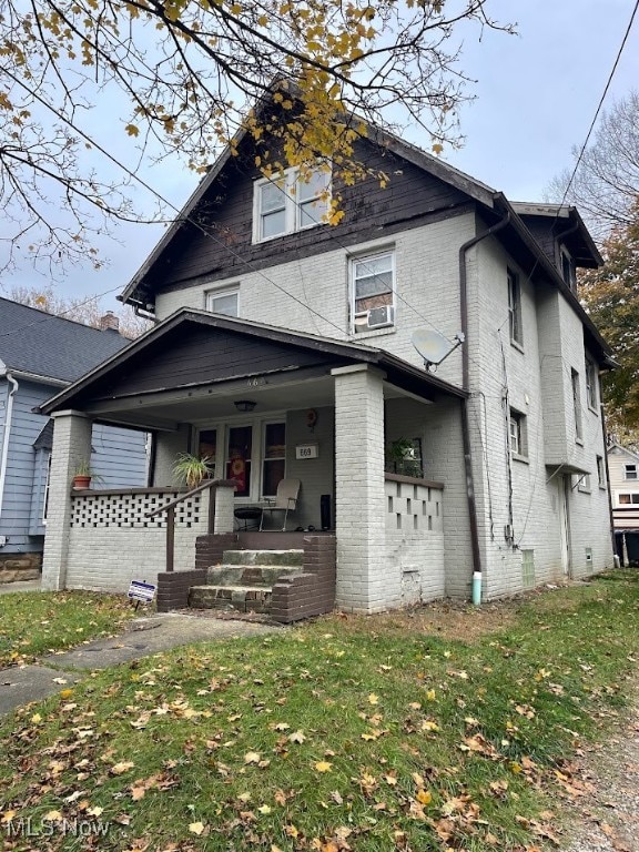 view of front of house with a porch and a front lawn