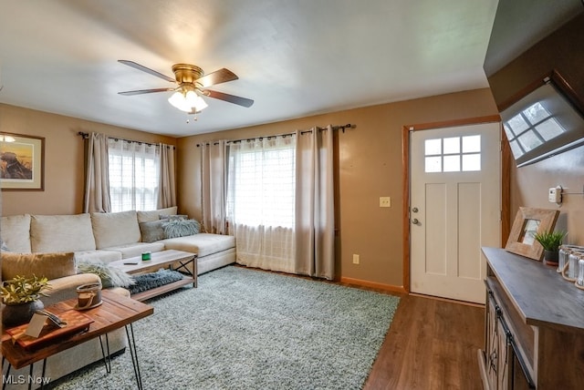 living room featuring ceiling fan, a healthy amount of sunlight, and dark hardwood / wood-style floors