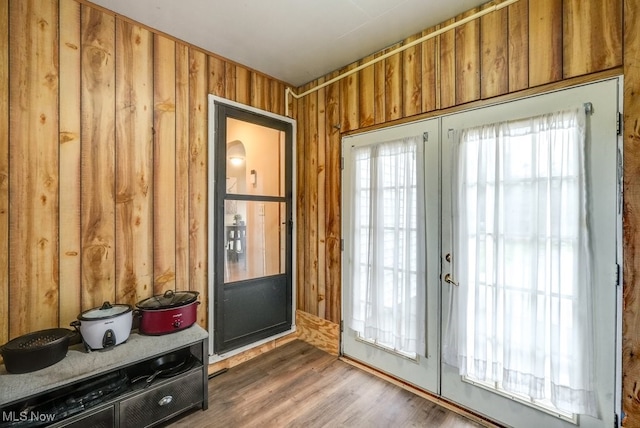 doorway to outside with french doors, dark hardwood / wood-style floors, and wooden walls