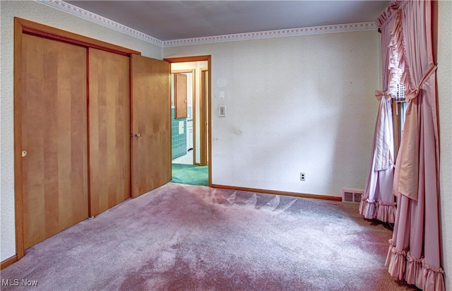 unfurnished bedroom featuring light carpet and a closet