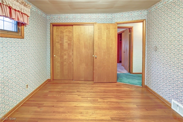 unfurnished bedroom featuring light hardwood / wood-style floors and a closet