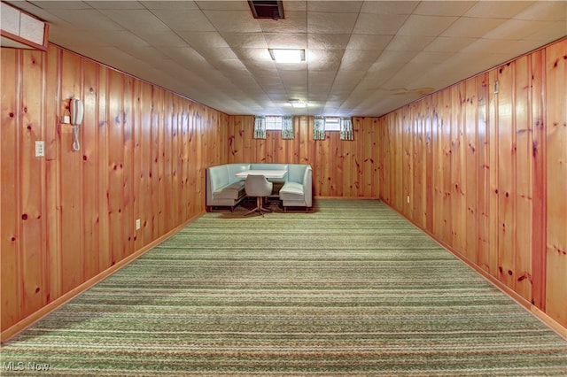 interior space featuring carpet flooring and wooden walls