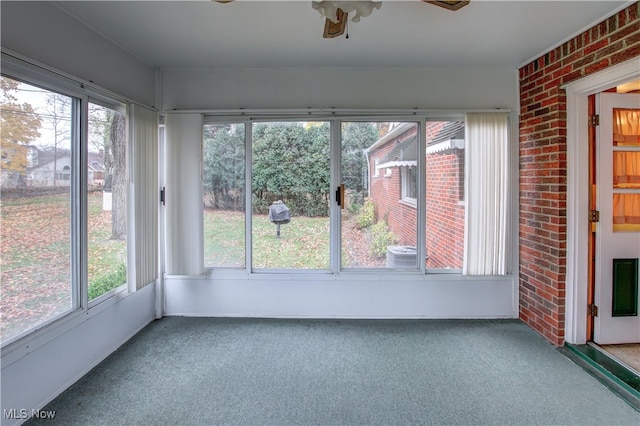 unfurnished sunroom with ceiling fan and plenty of natural light