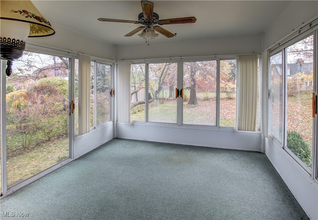 unfurnished sunroom with ceiling fan