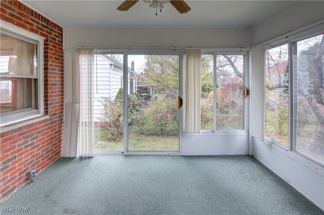 unfurnished sunroom featuring ceiling fan