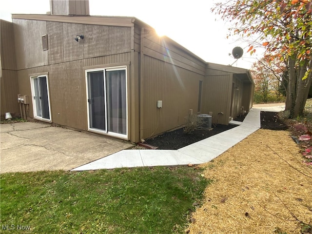 back of property with a yard, a patio, and cooling unit