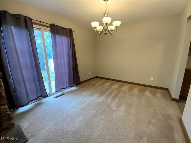 spare room featuring light colored carpet and a notable chandelier