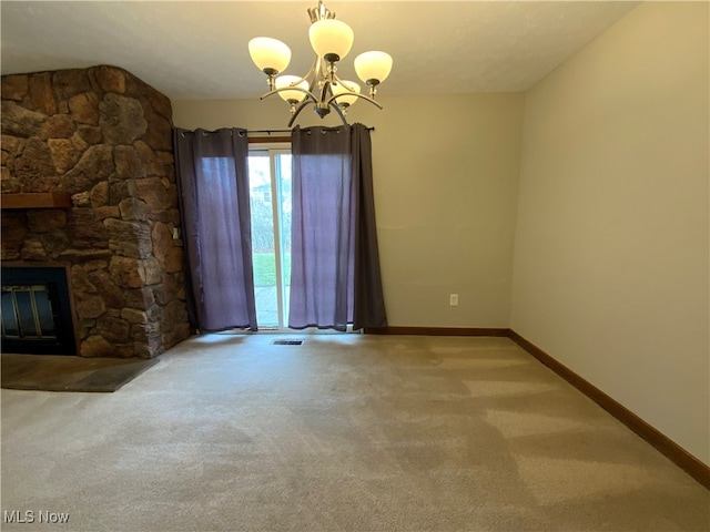 unfurnished living room with a fireplace, a textured ceiling, light colored carpet, and an inviting chandelier