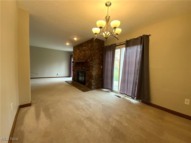 unfurnished living room with a chandelier, a fireplace, and light colored carpet