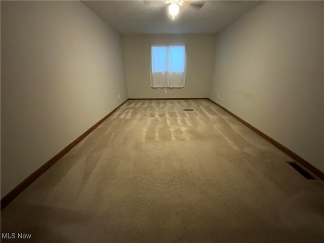 carpeted spare room featuring ceiling fan