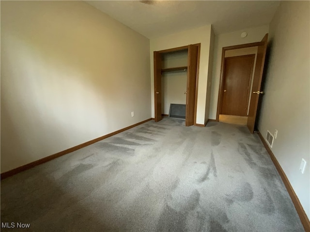 unfurnished bedroom featuring light colored carpet and a closet