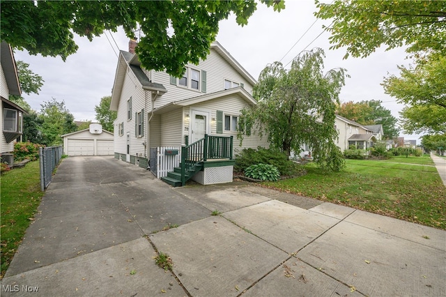 view of front of property featuring a garage, a front lawn, and an outdoor structure