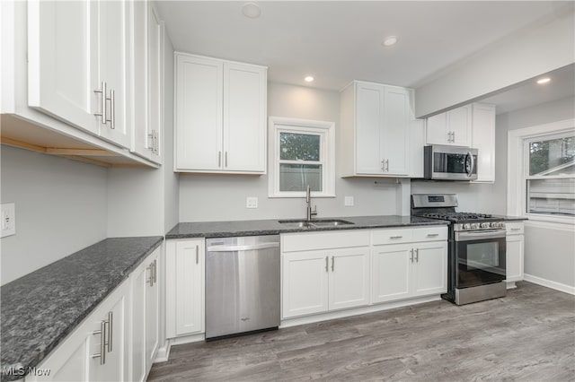 kitchen featuring a wealth of natural light, white cabinetry, sink, and stainless steel appliances