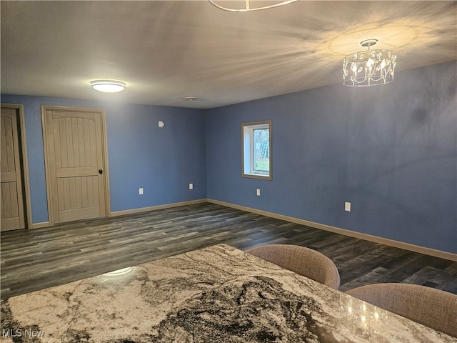 unfurnished room featuring dark hardwood / wood-style floors and an inviting chandelier