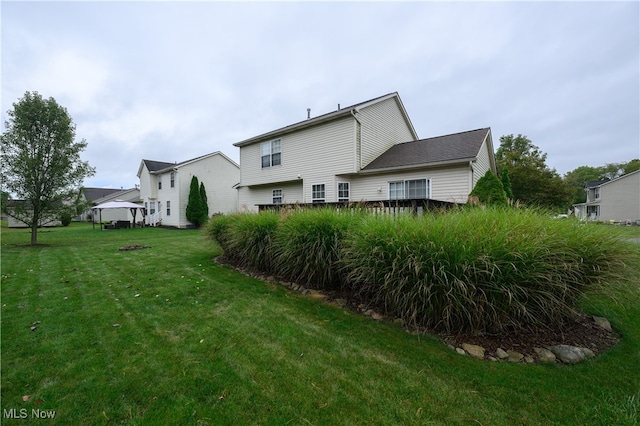 back of house featuring a lawn