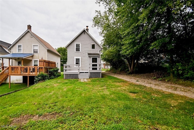 back of house with a wooden deck and a lawn