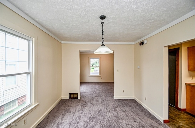 unfurnished dining area featuring carpet, crown molding, and a textured ceiling